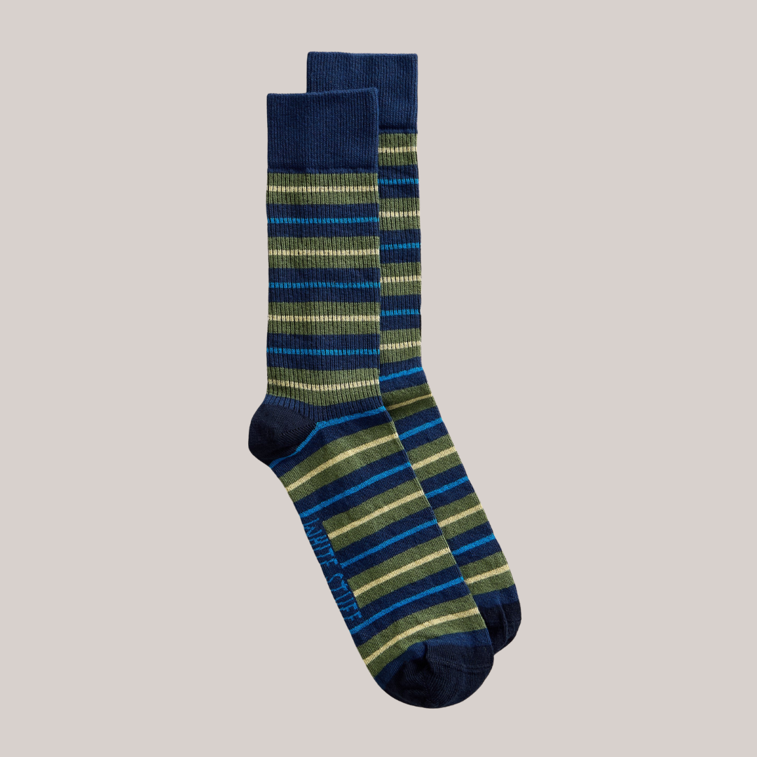 Pair of striped socks with blue and green pattern on a beige background