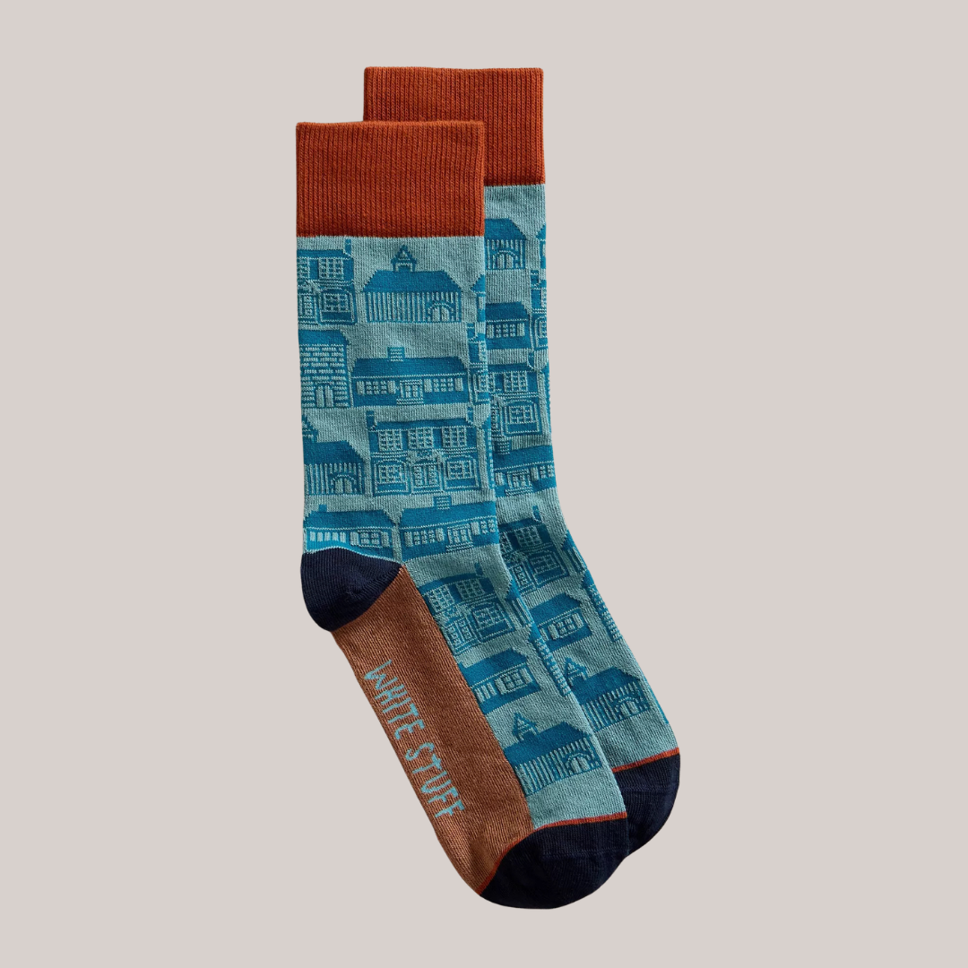 Pair of socks with blue house pattern and brown accents on a beige background