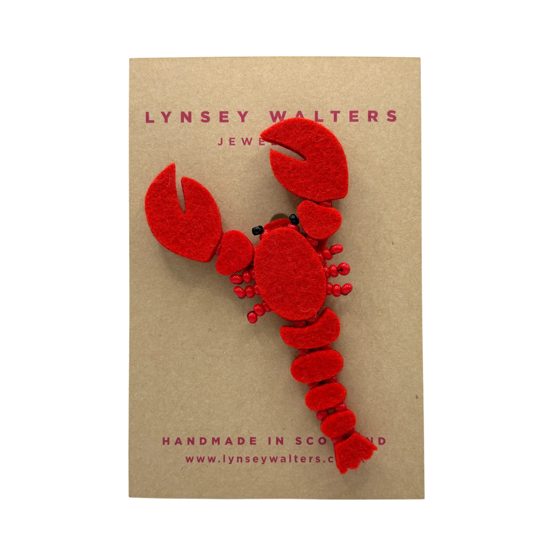 Red lobster-shaped brooch on a brown card with 'Lynsey Walters Jewellery' branding.