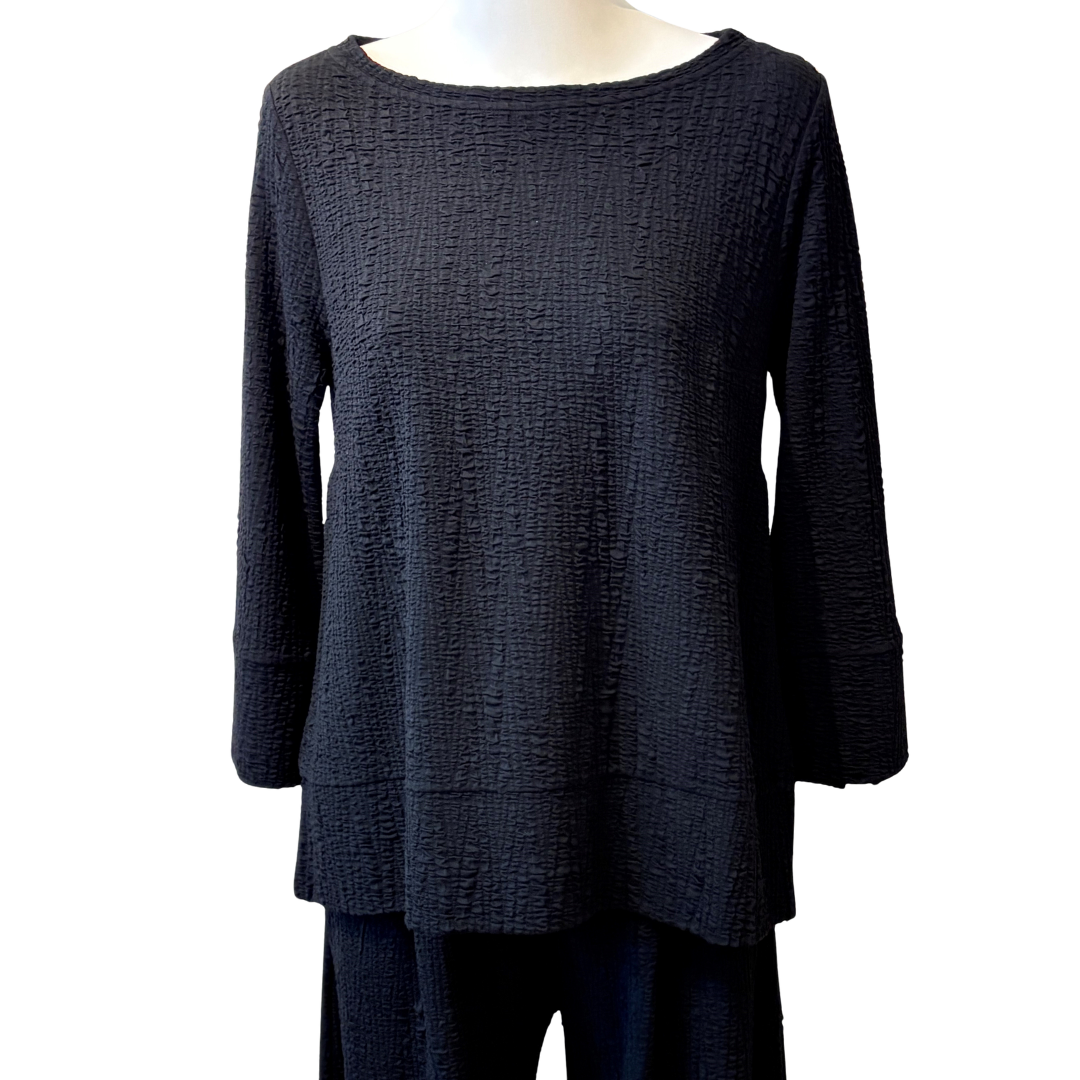 Black textured top on a mannequin against a white background