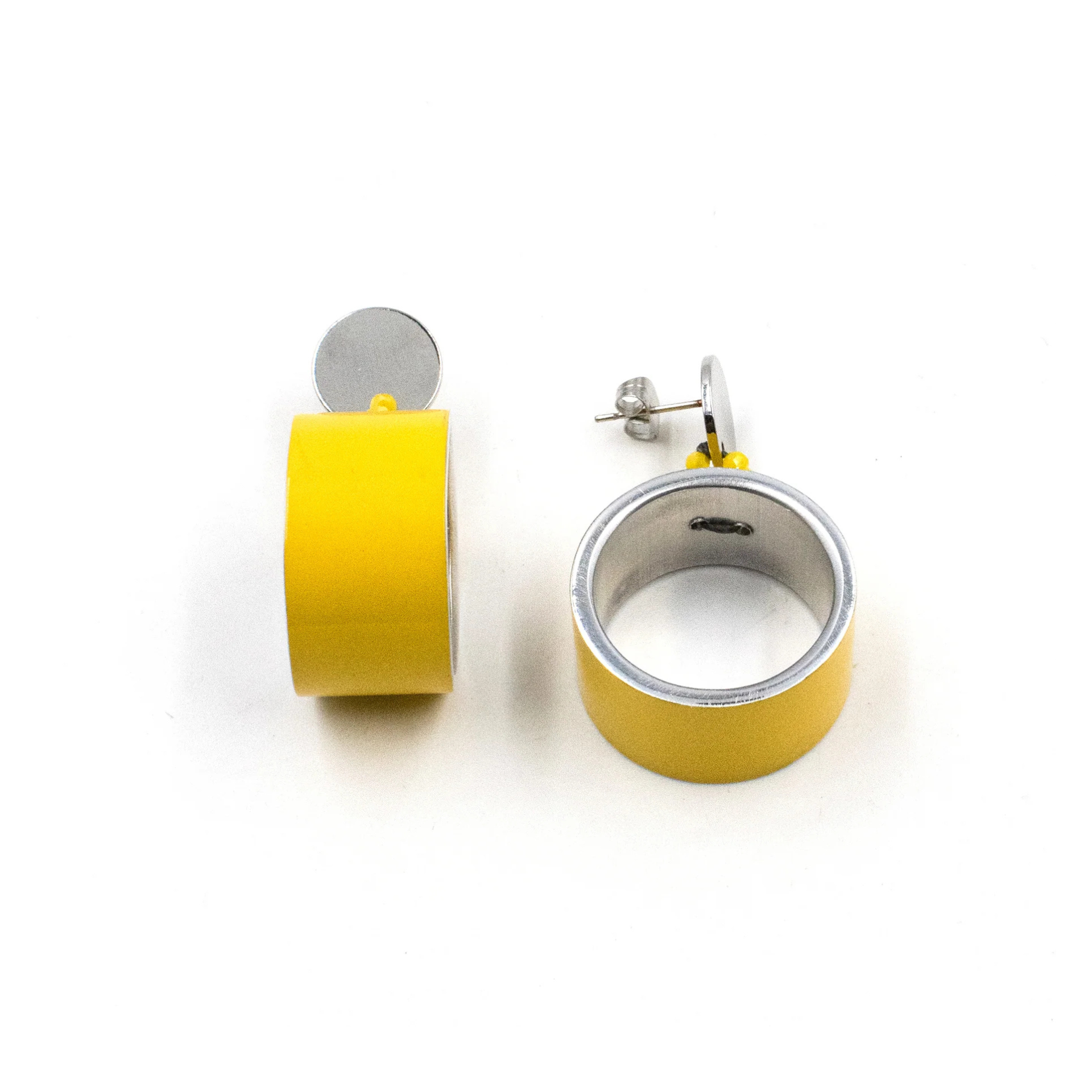 A pair of yellow and silver ring earrings shown on a plain white background, with one earring displaying the front face and the other showing its side