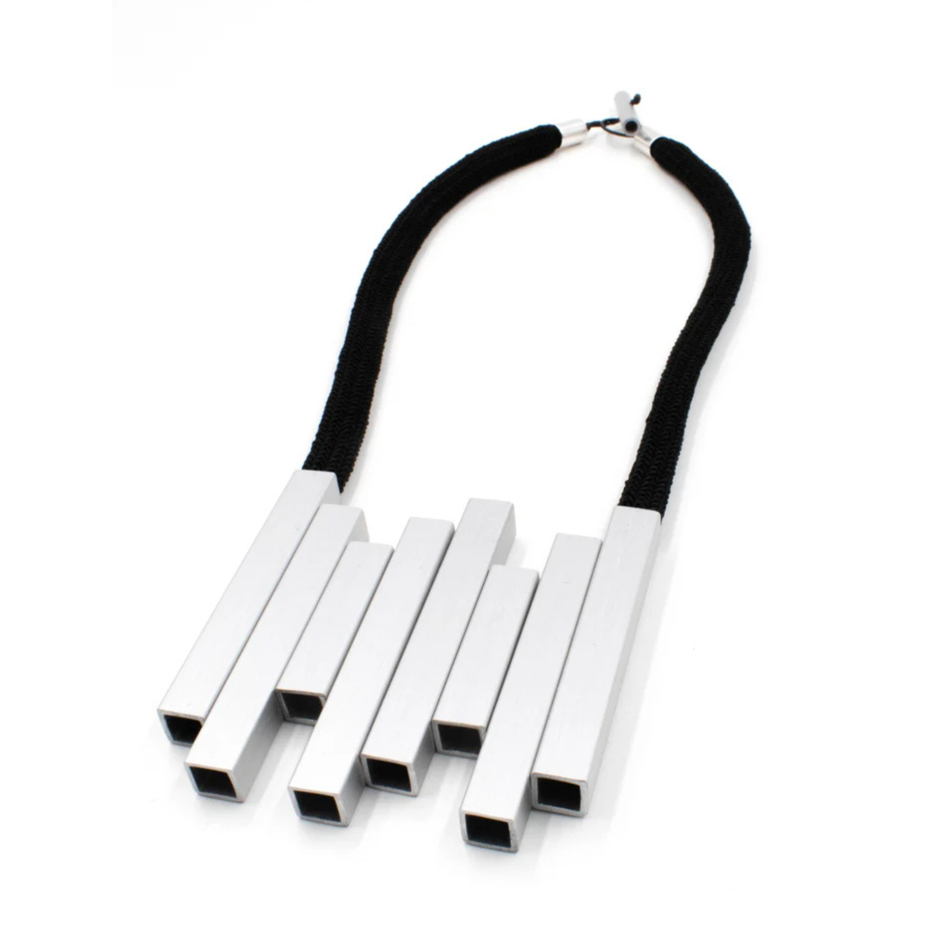 A modern geometric statement necklace featuring five parallel silver rectangular bars suspended from a thick black cord with a silver clasp, shown on a plain white background.