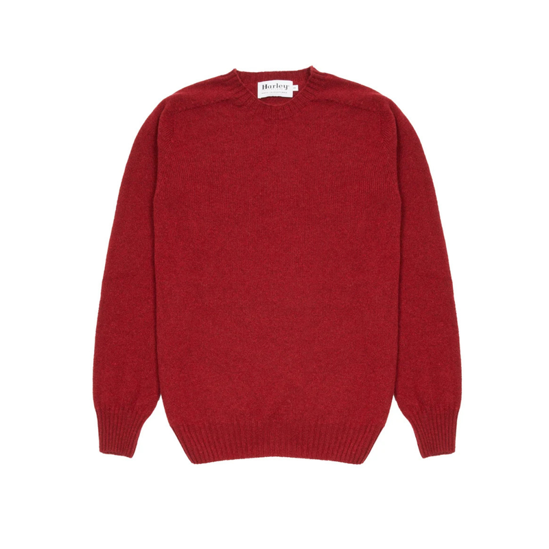 A classic crewneck knit sweater in a deep red color, laid flat against a solid white background. A small white label is visible inside the collar.
