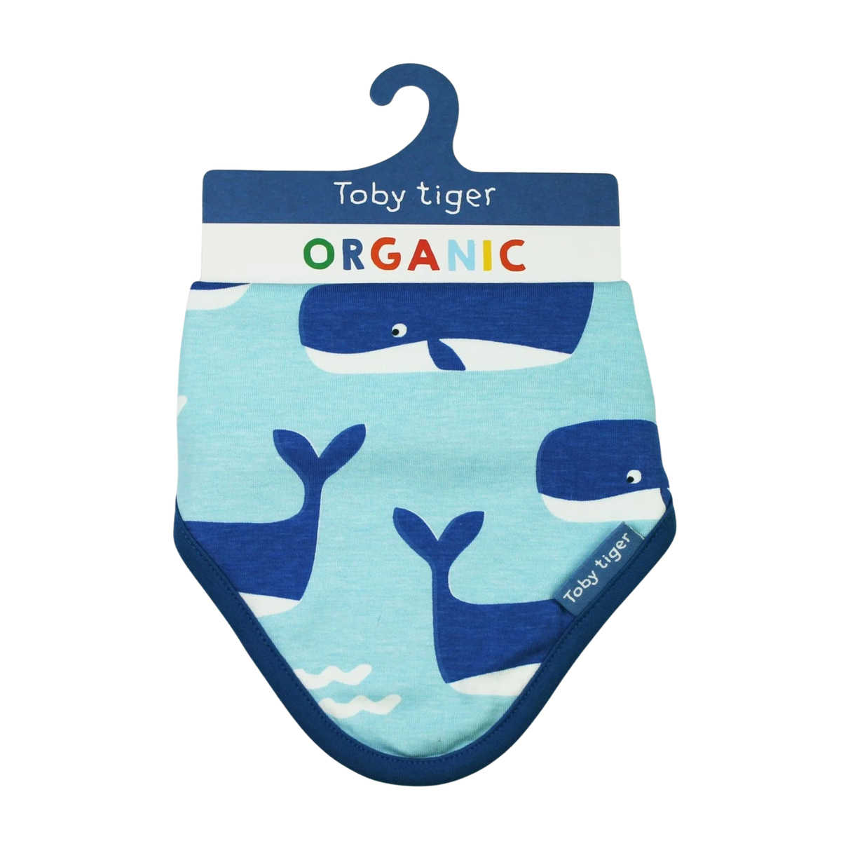 A baby bib with a whale print by Toby tiger, featuring a light blue body with navy blue whales and a navy blue border, hanging on a branded cardboard hanger.