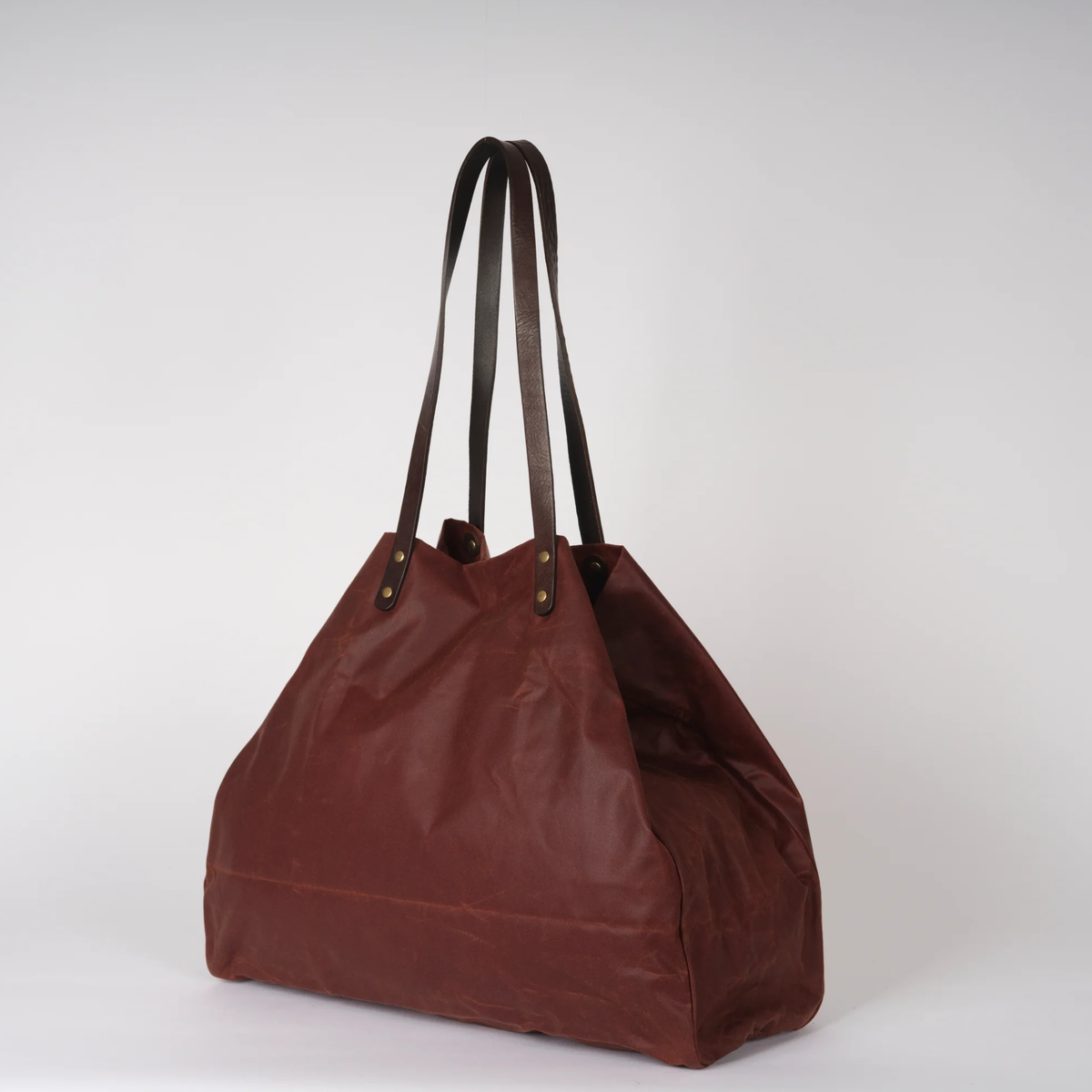 Brown tote bag with leather handles on a white background