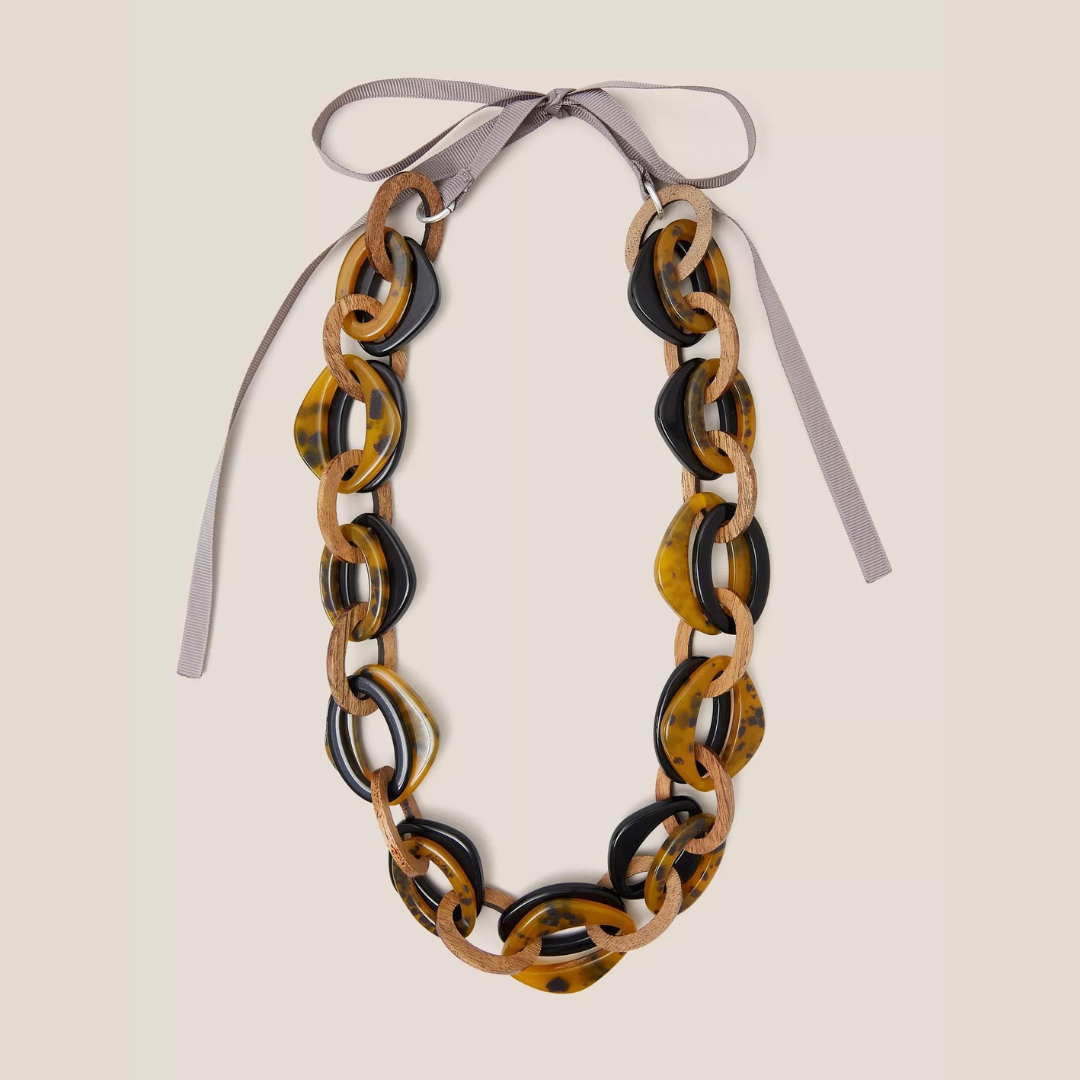 Statement necklace featuring a chain of linked tortoiseshell and black resin ovals interspersed with light brown wooden