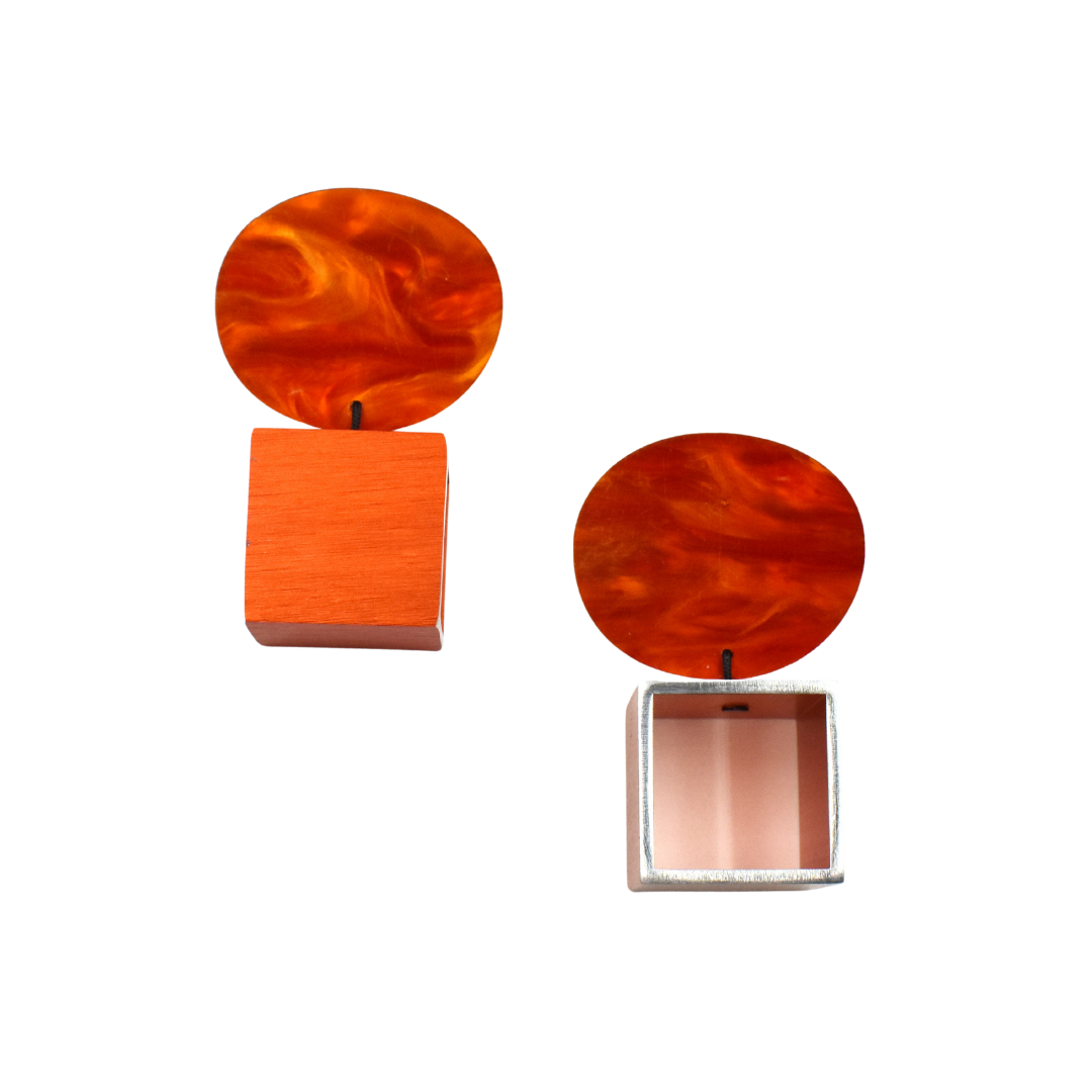 Pair of modern earrings.  Each features a marbled orange circle atop a geometric orange and silver square.