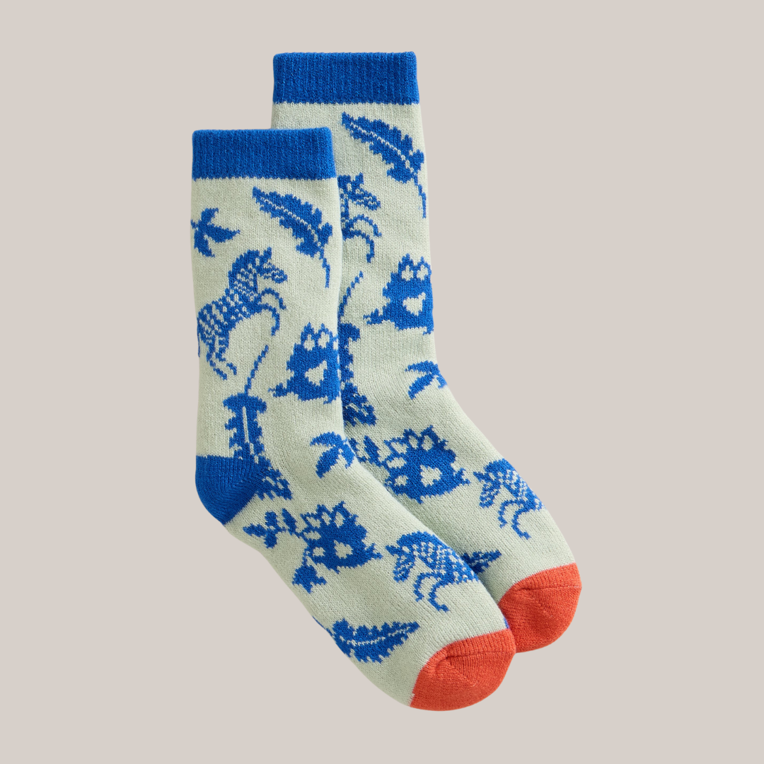 Pair of socks with blue dinosaur pattern on a beige background