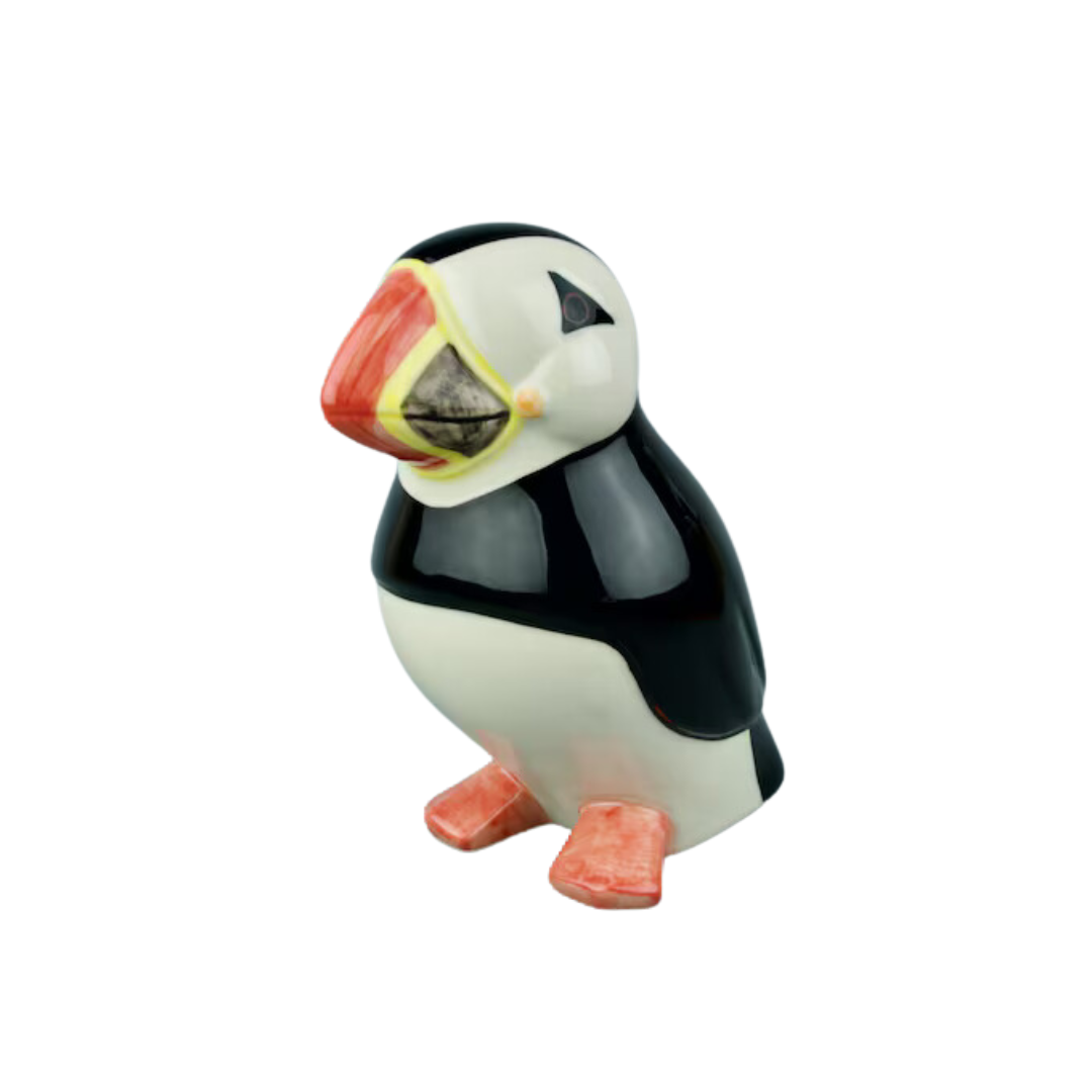 Ceramic puffin figurine, black and white with orange beak and feet.