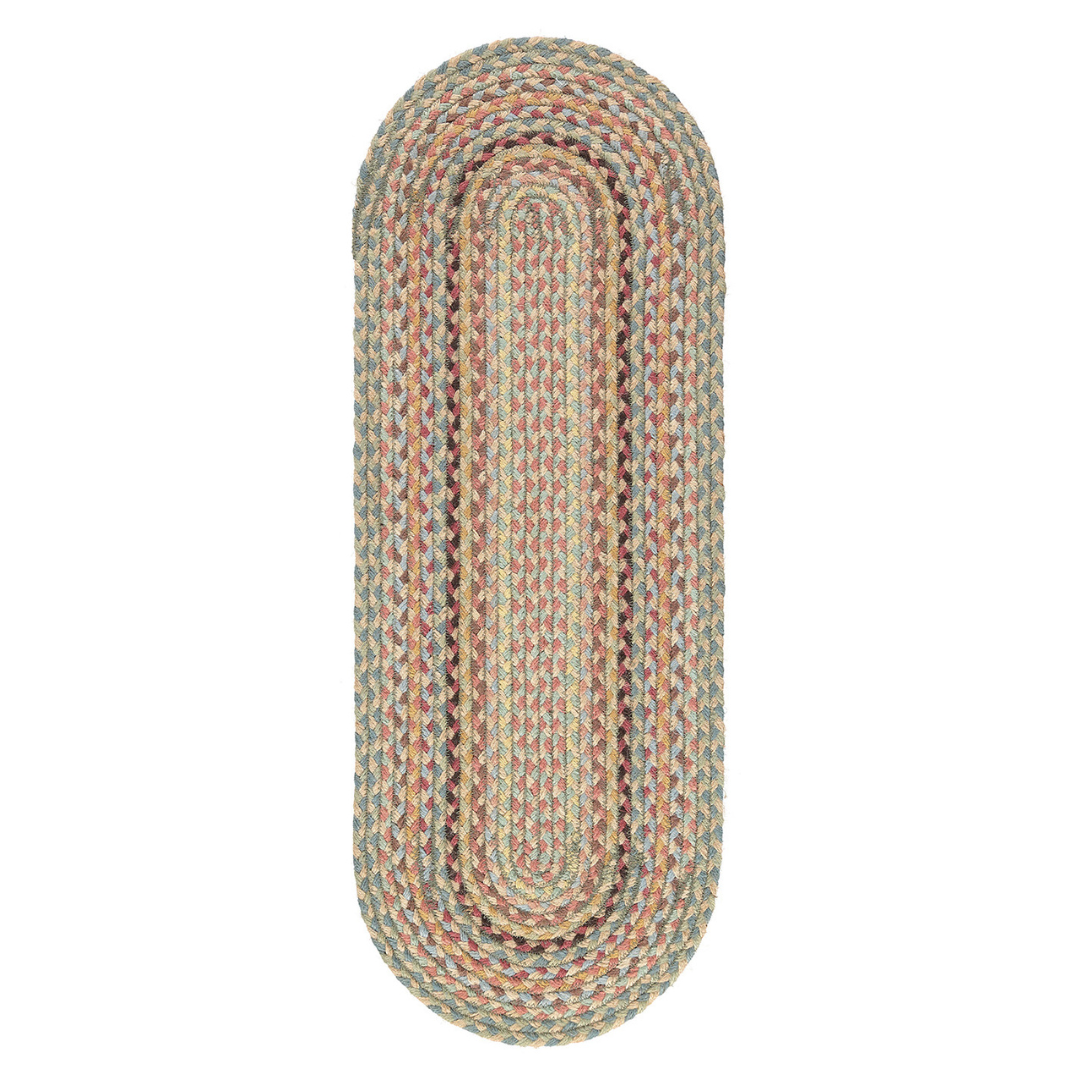 Oval braided rug in muted blues, pinks, and tans.