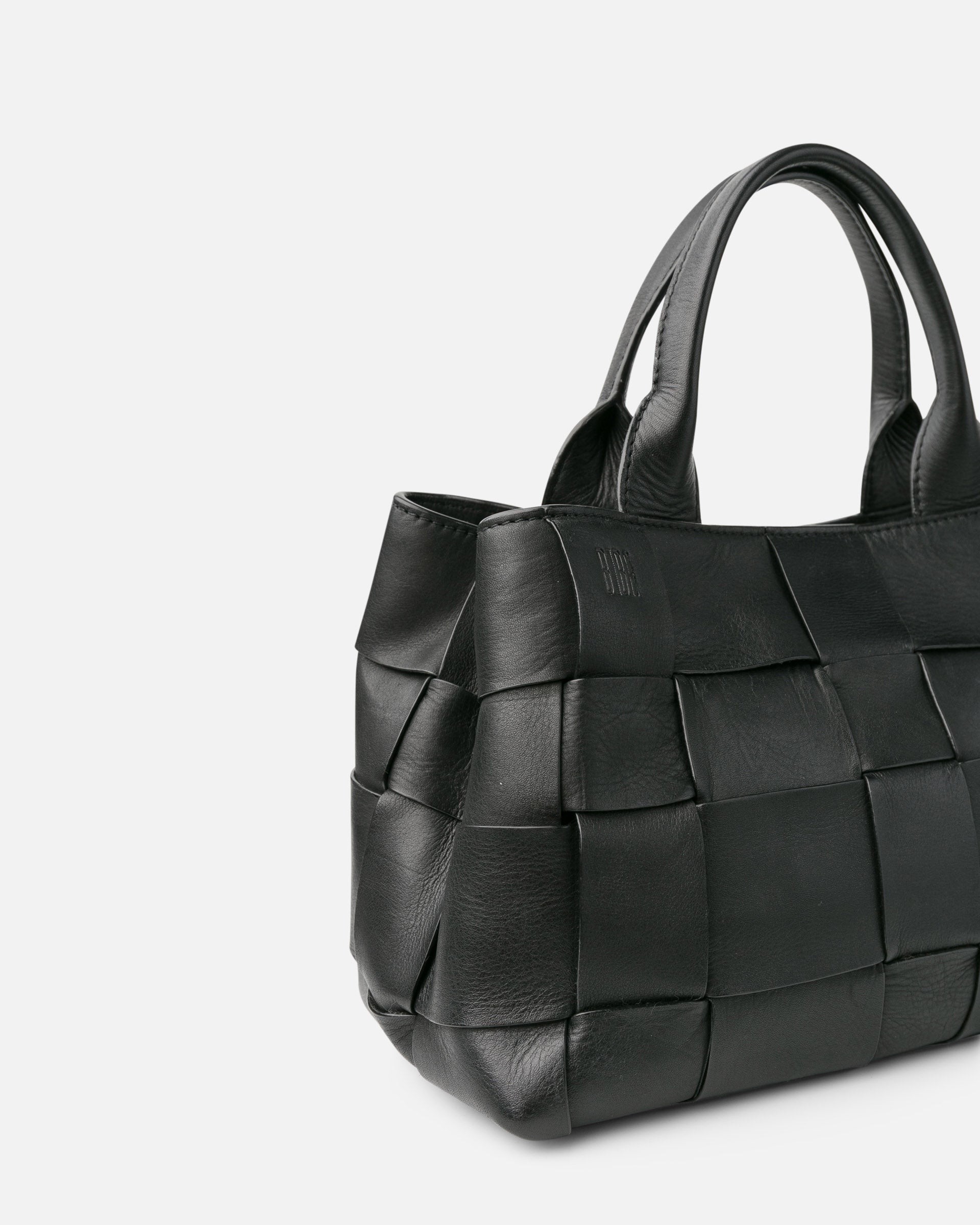 Black woven handbag on a light gray background