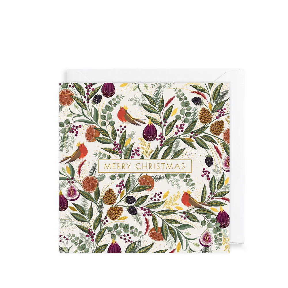A square Christmas greeting card with an illustrated botanical and bird pattern, shown with a white envelope behind it on a light gray background. The card reads “MERRY CHRISTMAS” in a gold-bordered box near the center.