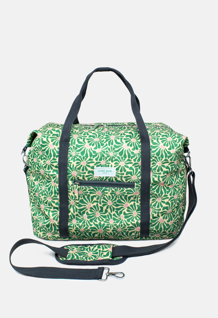 Green and beige floral-print duffel bag with black straps and shoulder strap.  Features a small zippered pocket on the front.