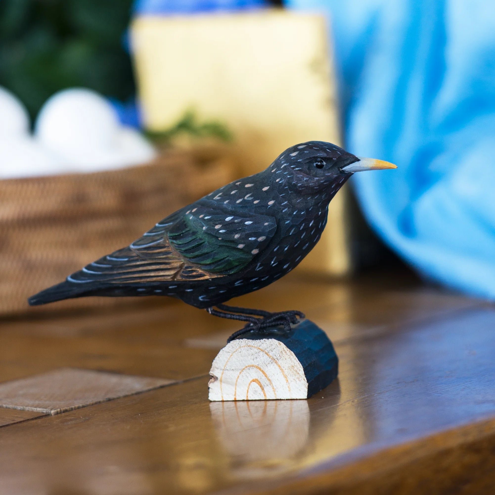 Black bird figurine on a wooden block with blurred background