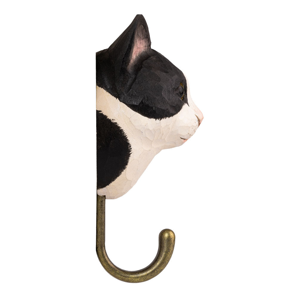 Side view of a wall hook shaped like a cat's head with a brass finish on a white background