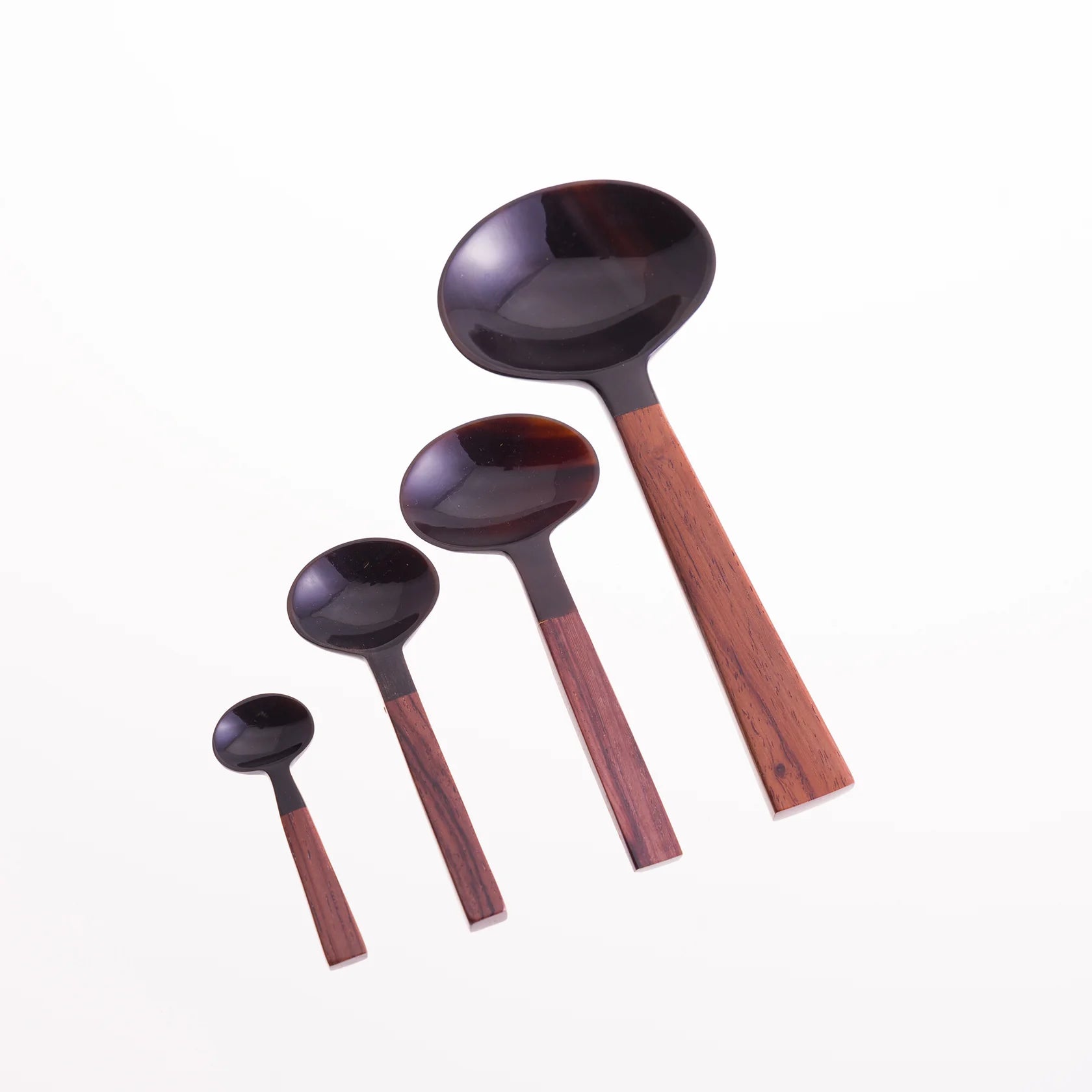 Set of four dark-colored spoons with reddish-brown wooden handles, graduating in size from small to large.