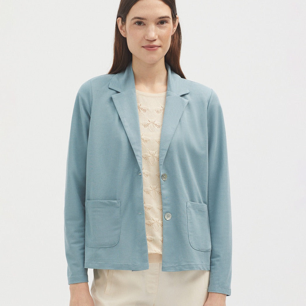 Dusty blue women's blazer with notched lapels, two patch pockets, and a single button closure.