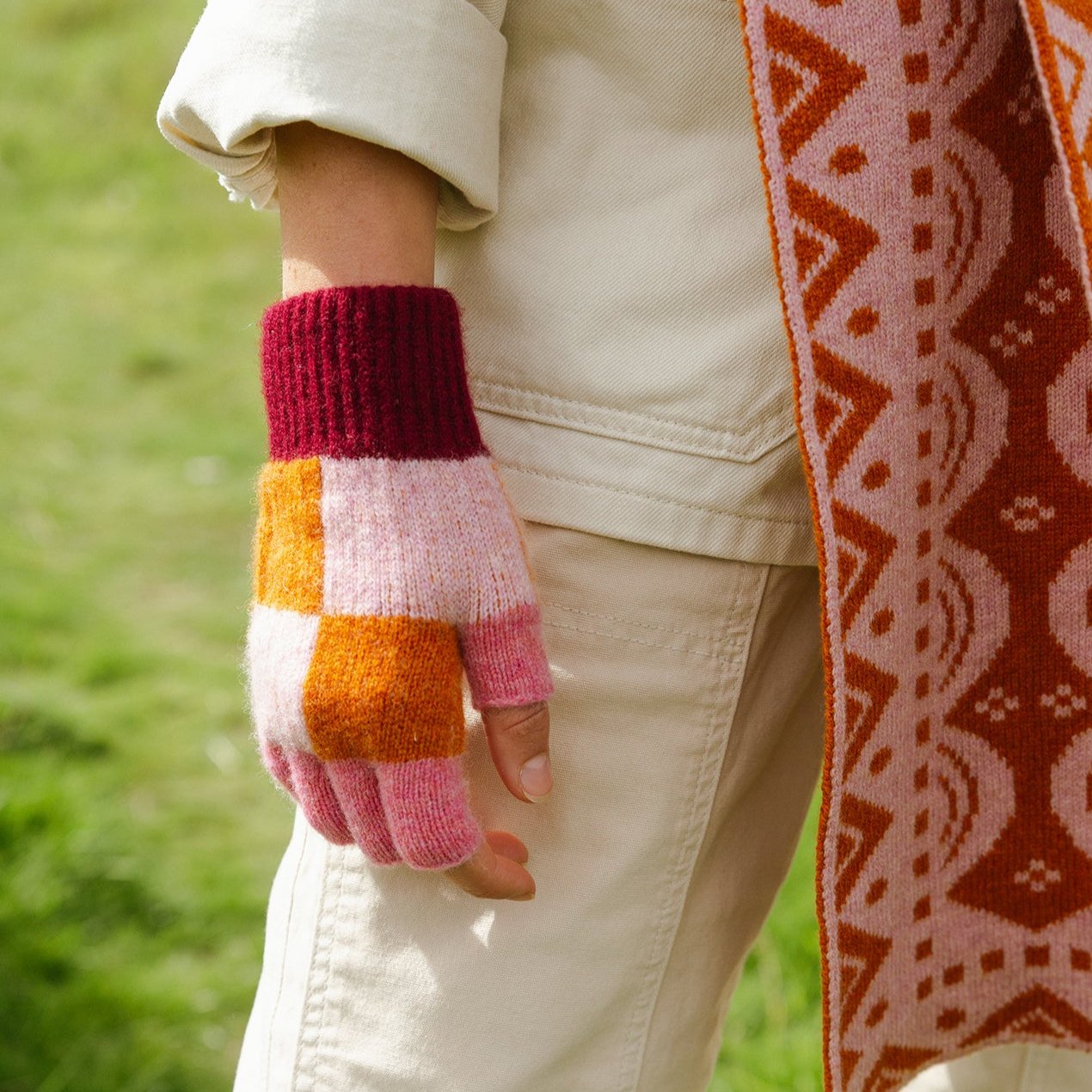 Warm fingerless gloves in burgundy, pink, and orange color-blocked knit.