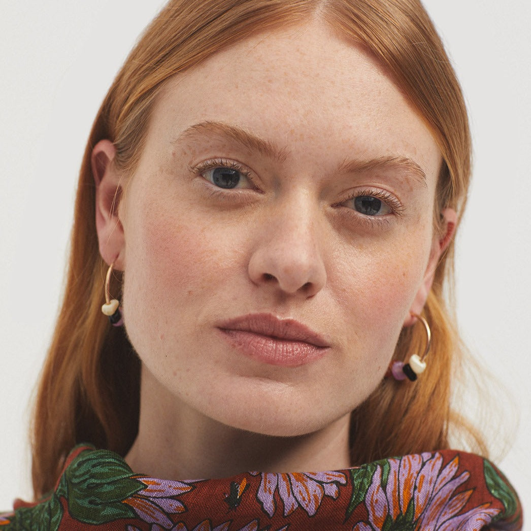 Gold hoop earrings with small, multi-colored beads.