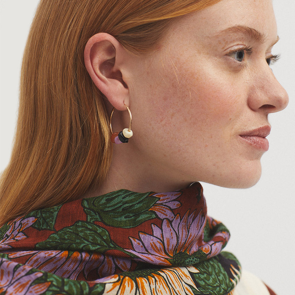 Gold hoop earrings adorned with small, multicolored beads.