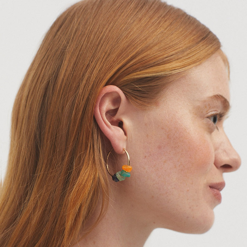 Gold hoop earrings adorned with small, multicolored stones.