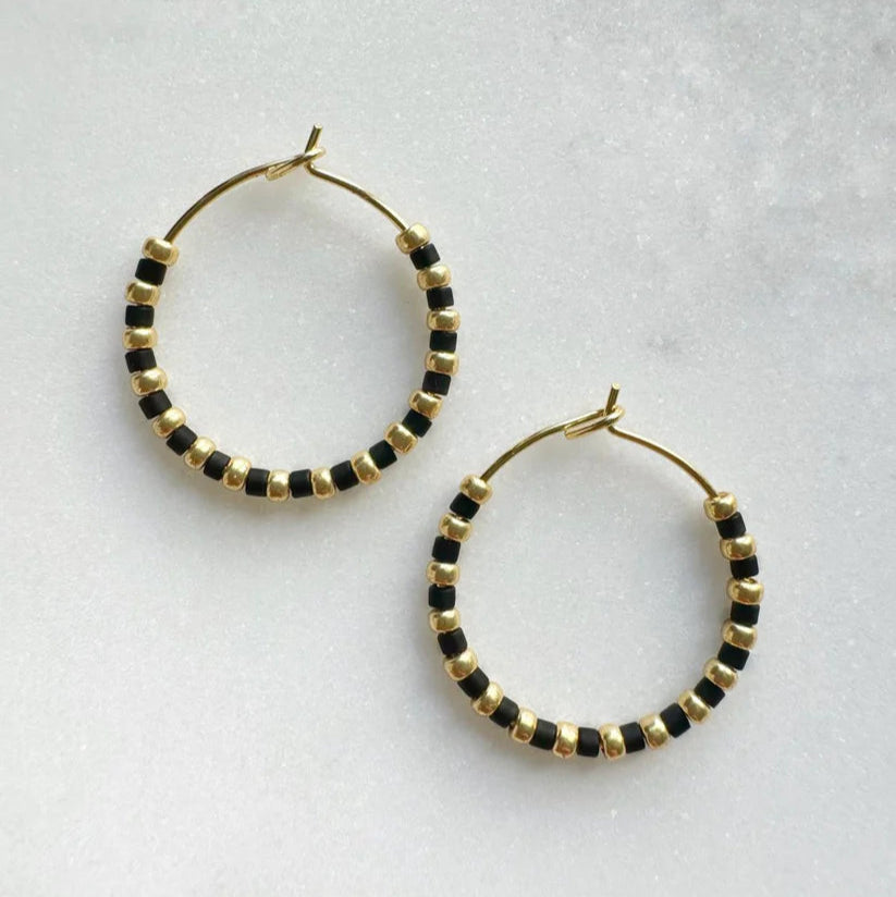 Gold hoop earrings adorned with alternating black and gold beads.