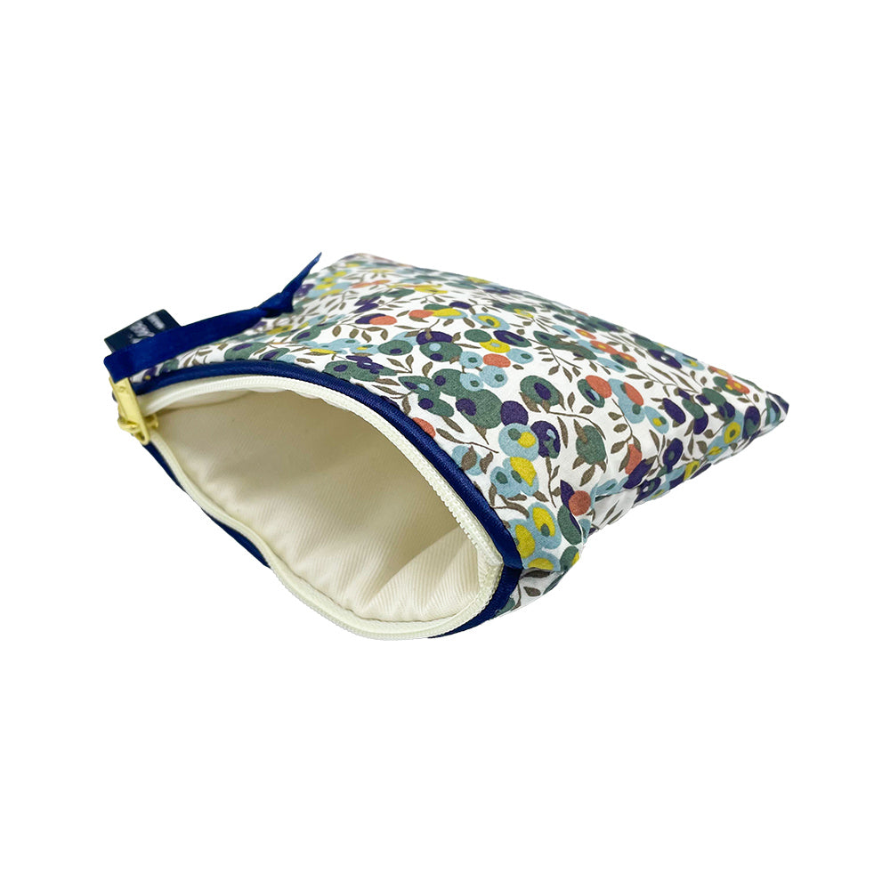 Small zippered pouch with a floral print and navy blue trim. The interior is a light beige fabric.