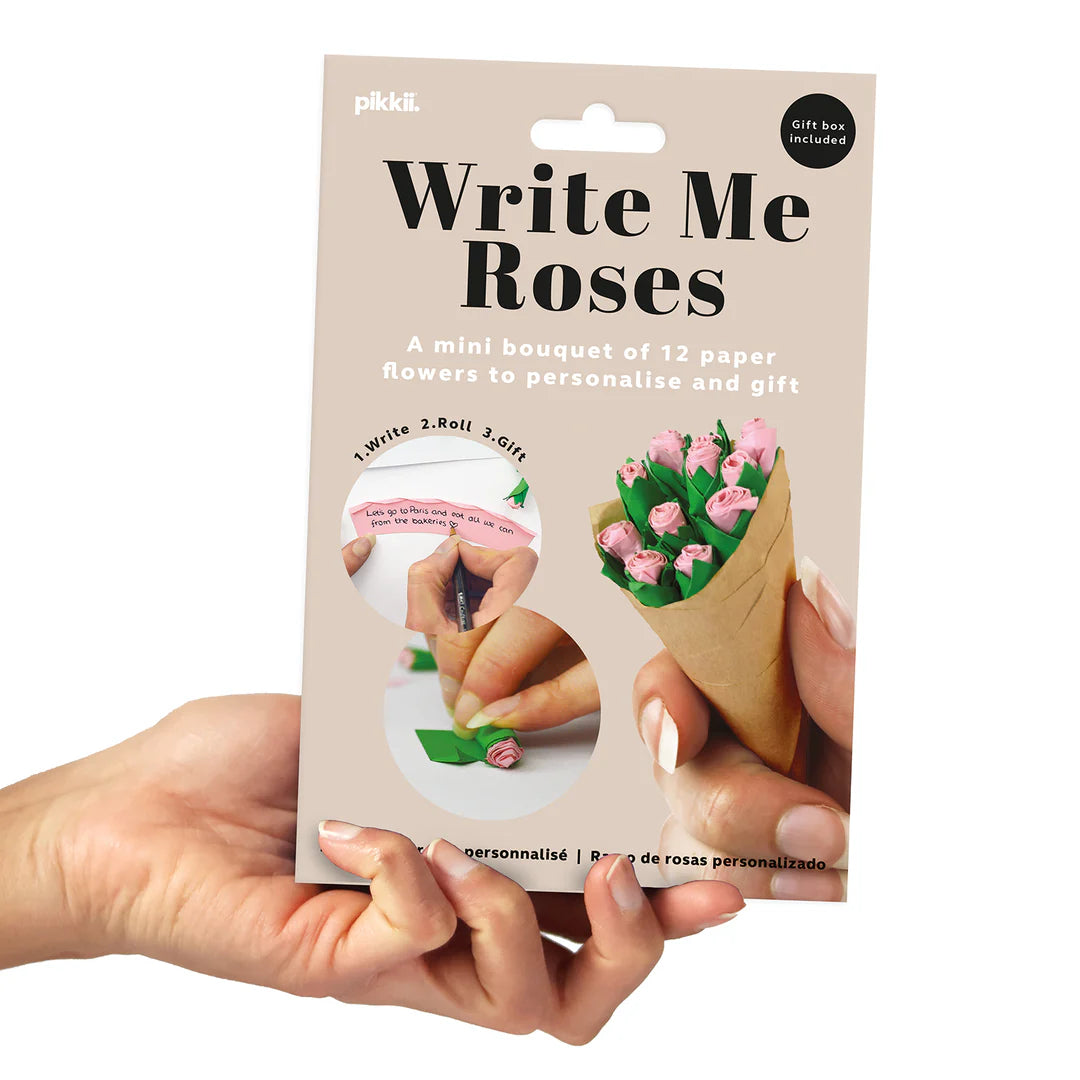 Packaging of 'Write Me Roses' product with hands holding a cone of paper flowers.