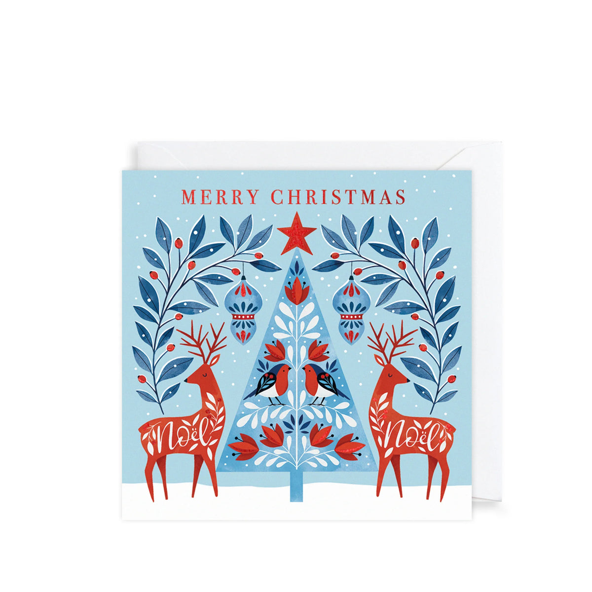 A square Christmas greeting card with a light blue background, featuring red and blue illustrated deer, a decorated Christmas tree, and the words “MERRY CHRISTMAS” at the top. A white envelope is partially visible behind the card on a white background.