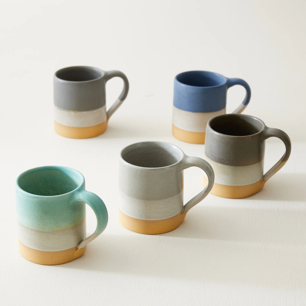 Five stoneware mugs in varying shades of blue, gray, and teal.