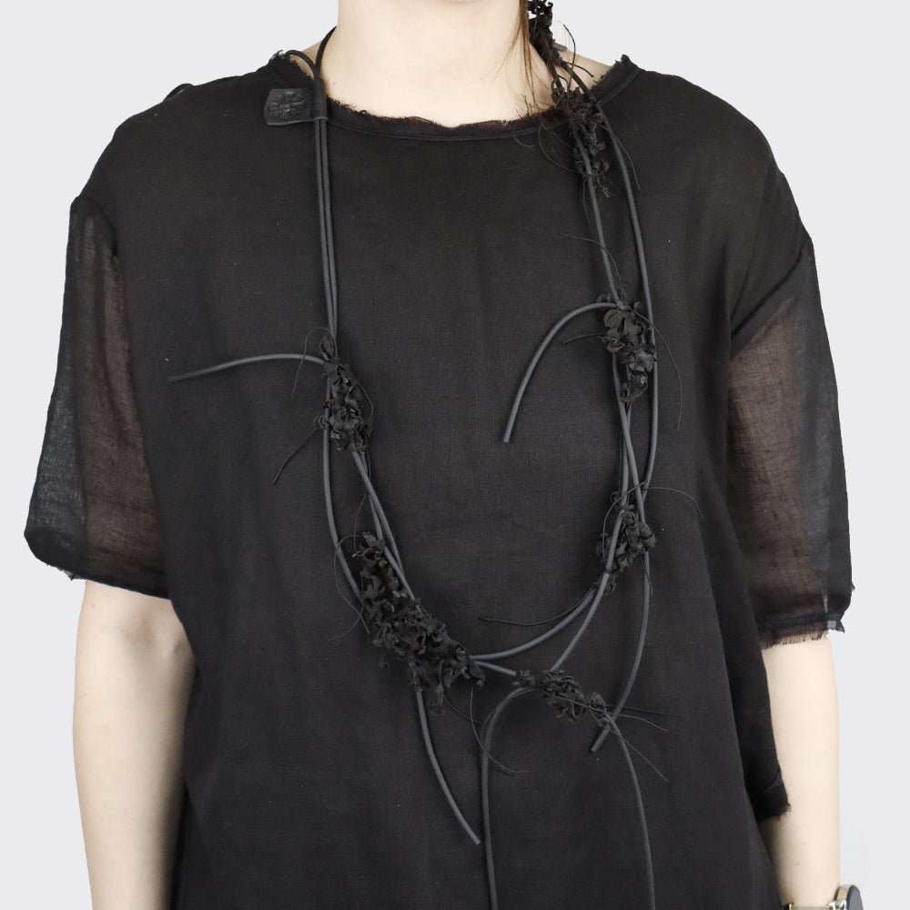 Black necklace with sculptural, organic-shaped elements.