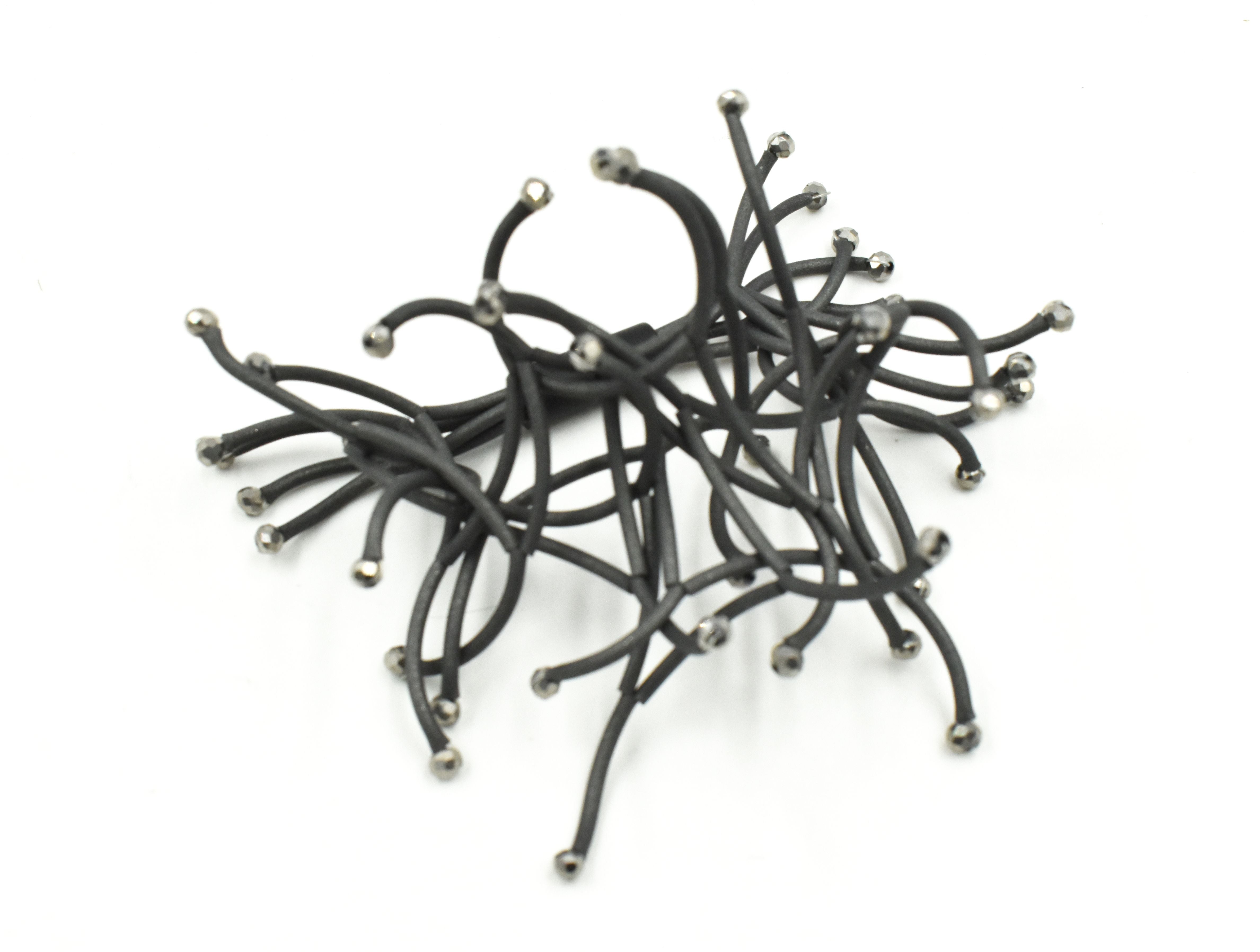 Black hair clip with numerous curved arms, each tipped with a small, metallic bead.