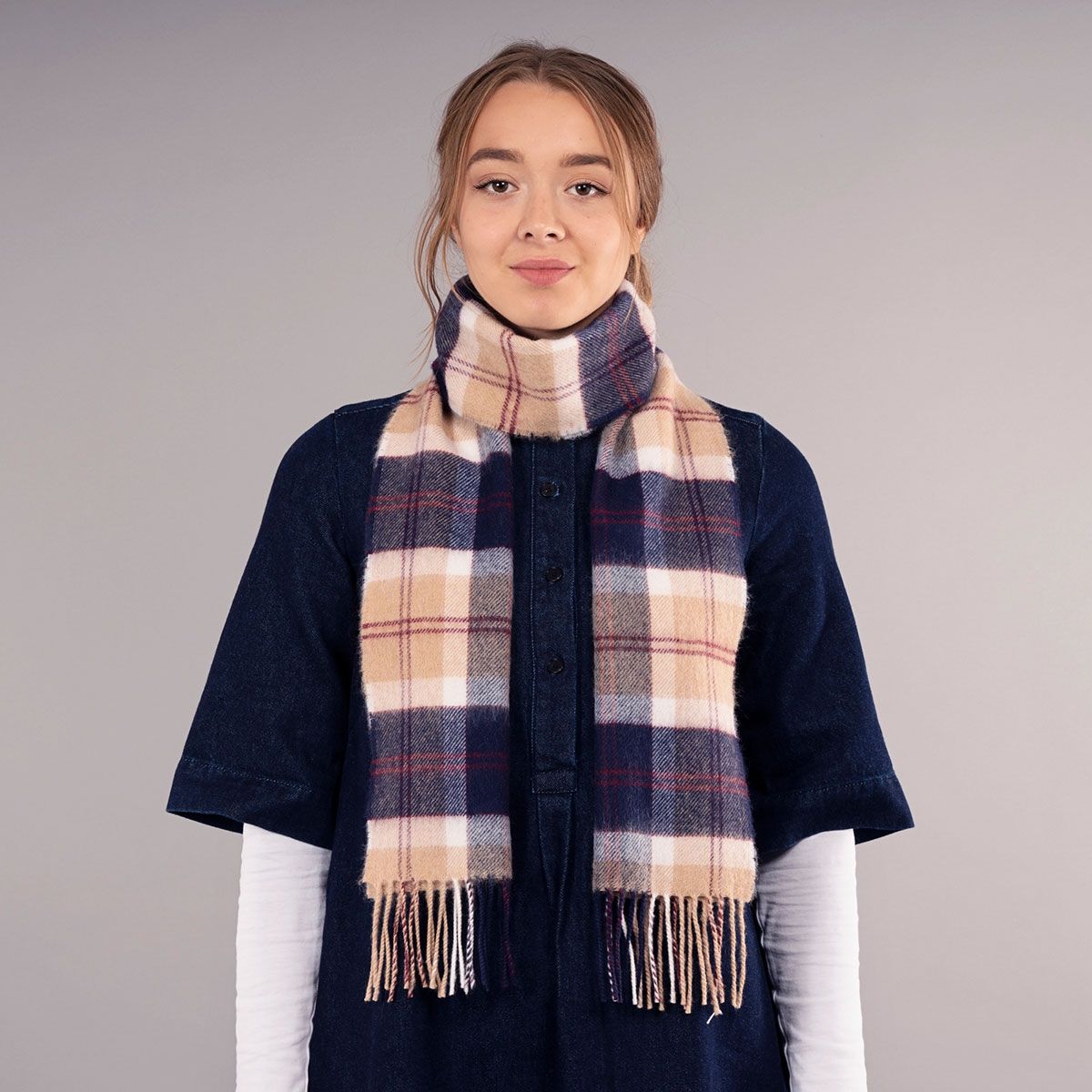 Beige, navy, and burgundy plaid wool scarf with fringed edges.