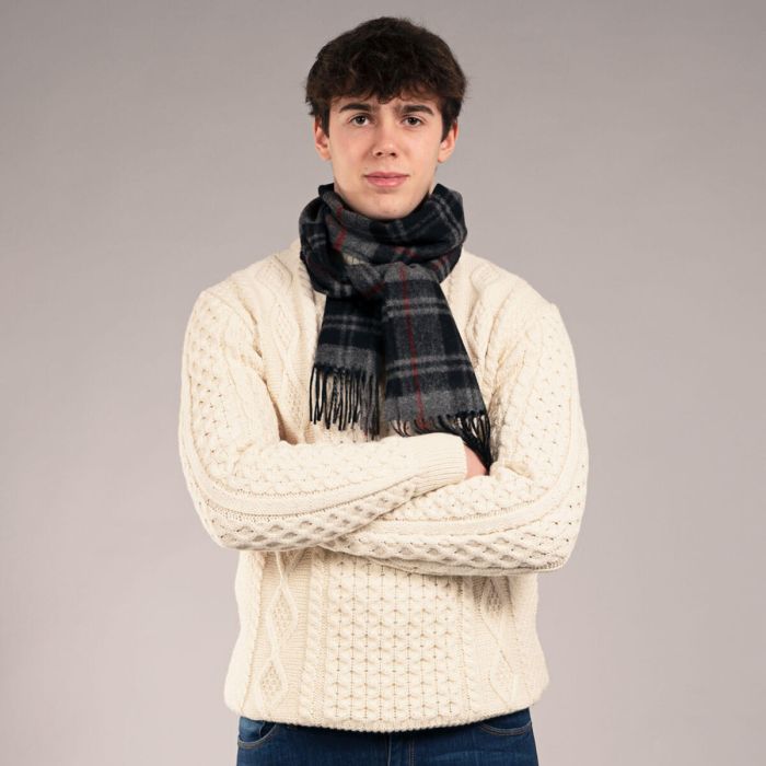 Cream cable knit sweater with a dark gray and red plaid scarf.