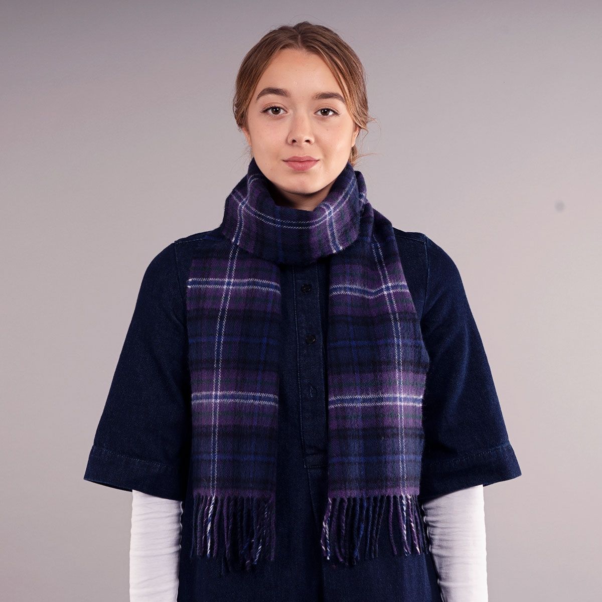 Purple, blue, and white plaid wool scarf with fringed edges.