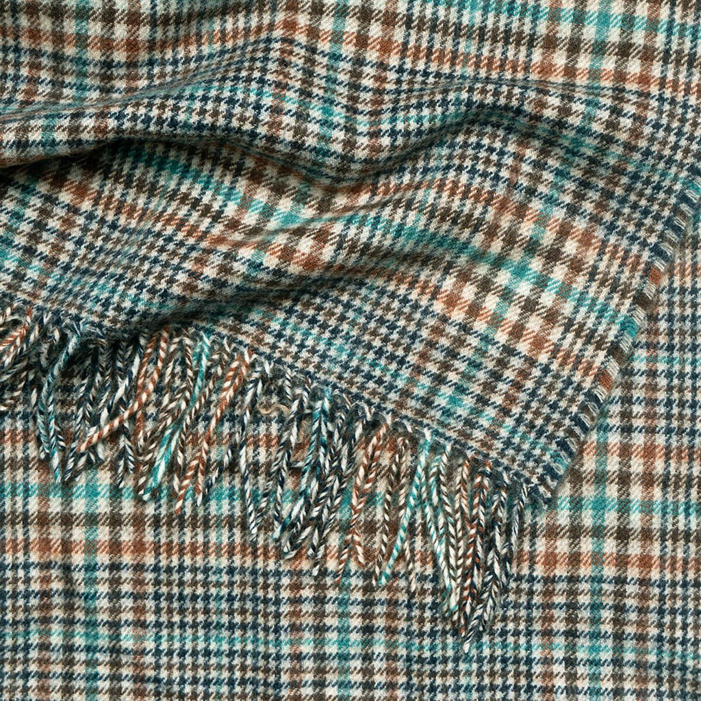 Woven plaid throw blanket with teal, brown, and beige pattern and fringed edge.