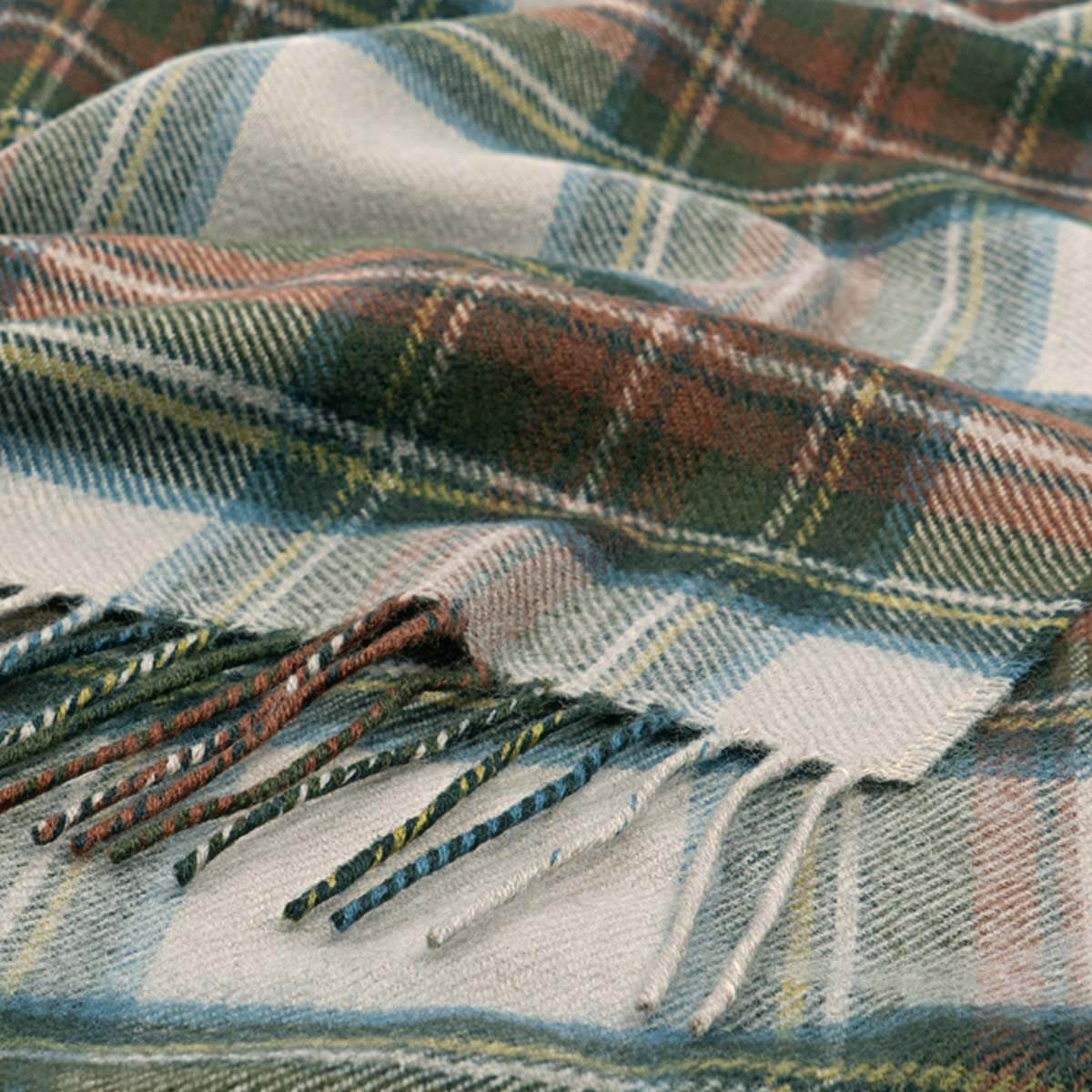 Plaid fabric with a tassel on a neutral background