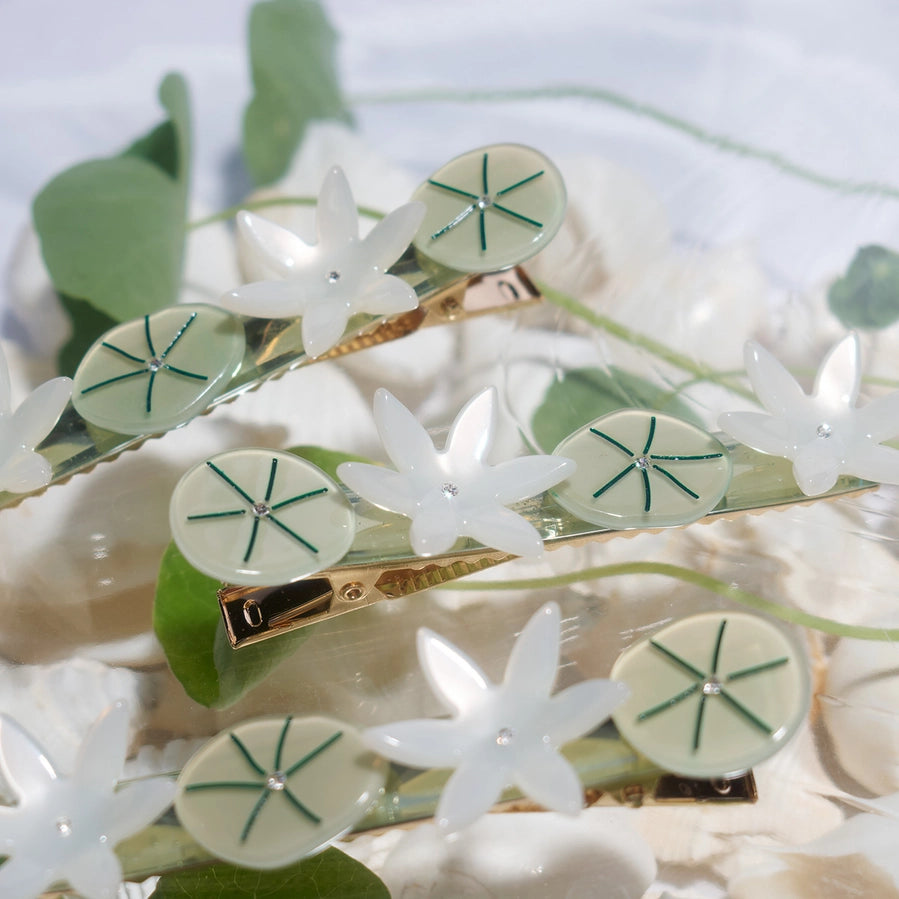 Hair clip with white flower designs on a floral background