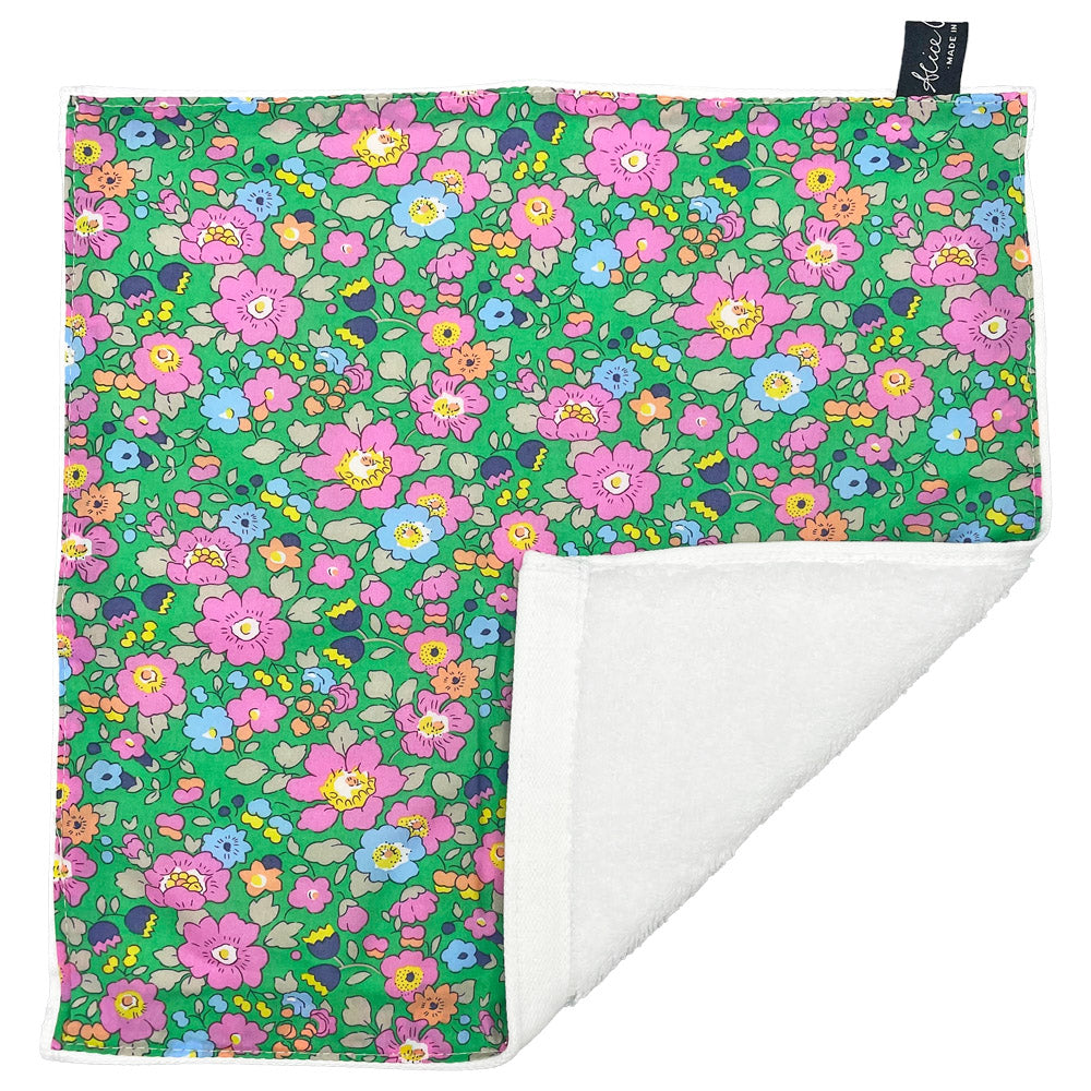 Floral-printed cotton washcloth with a white terry cloth backing.