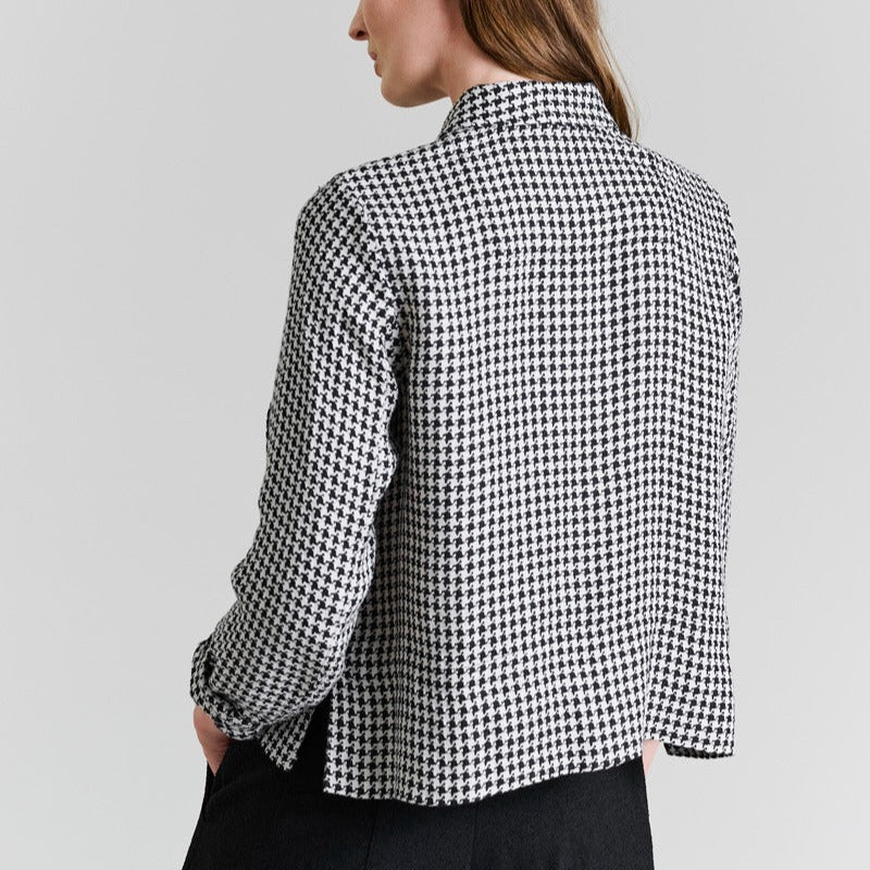 Woman wearing a black and white checkered shirt on a light gray background