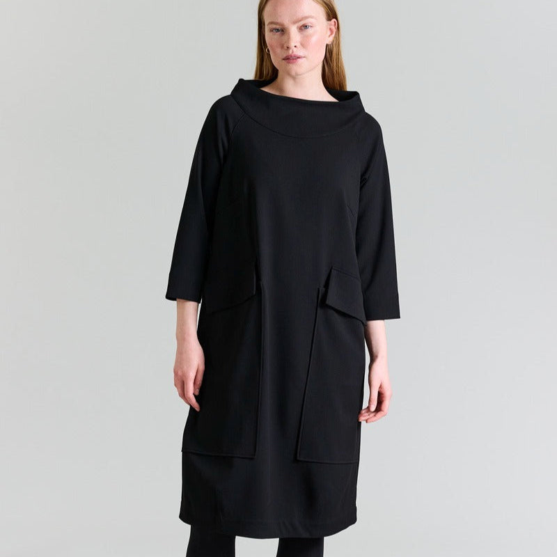 Woman wearing a black dress on a gray background