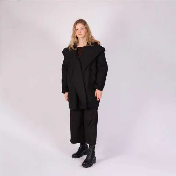 Black hooded coat with an asymmetrical overlap, knee-length, and loose fit.