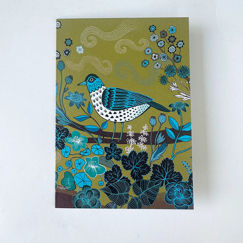 Notebook cover with a blue bird and floral design on a green background