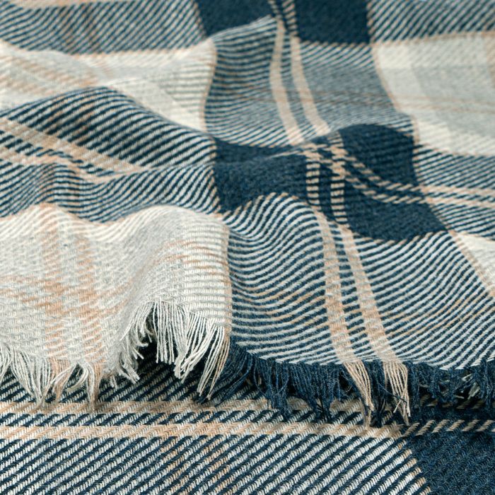 Soft, textured plaid throw blanket in teal and beige. Frayed edges visible.
