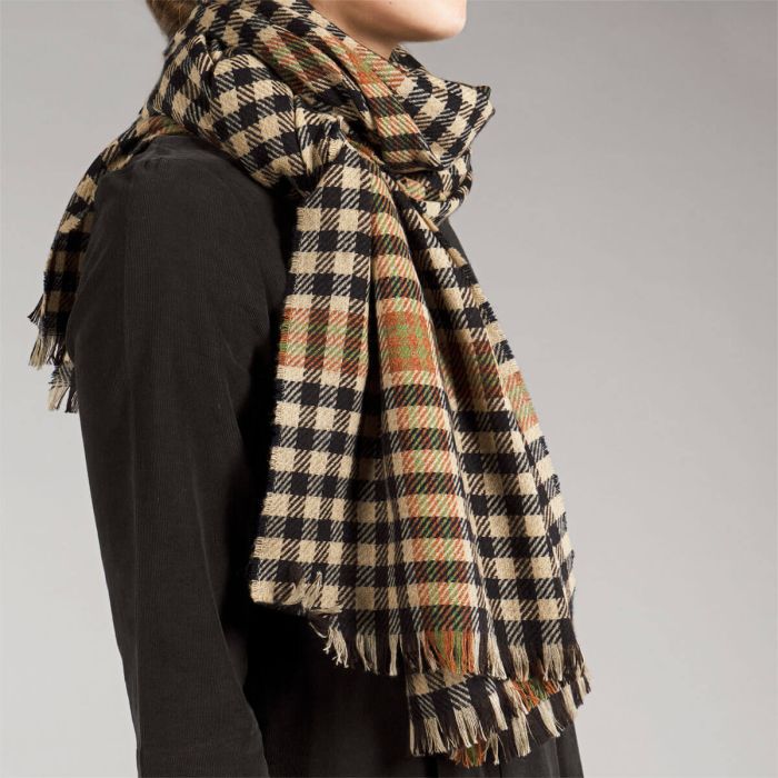 Black and beige gingham scarf with frayed edges and hints of orange and green woven into the pattern.