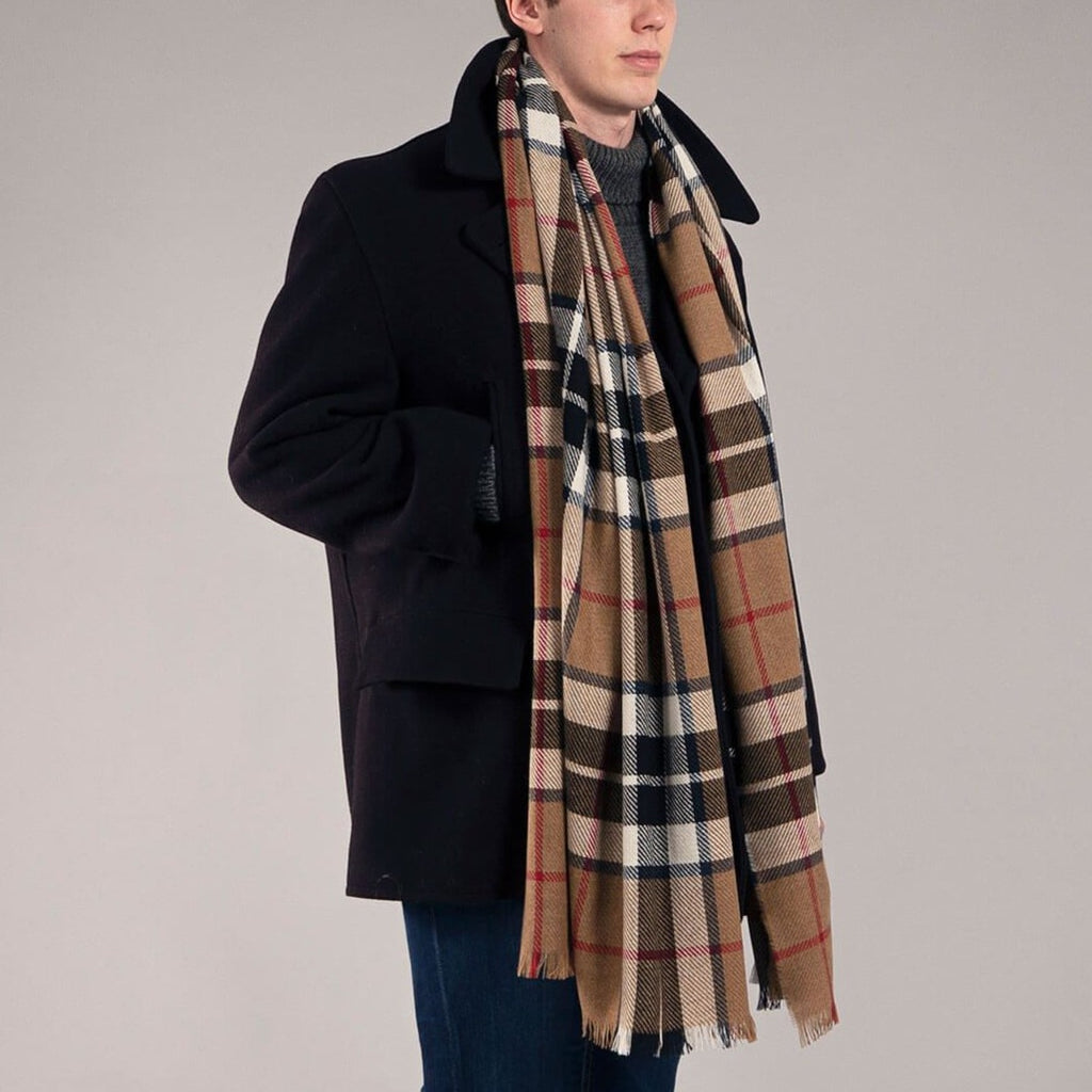 Tan, black, and white plaid scarf with frayed edges, worn over a dark navy peacoat.