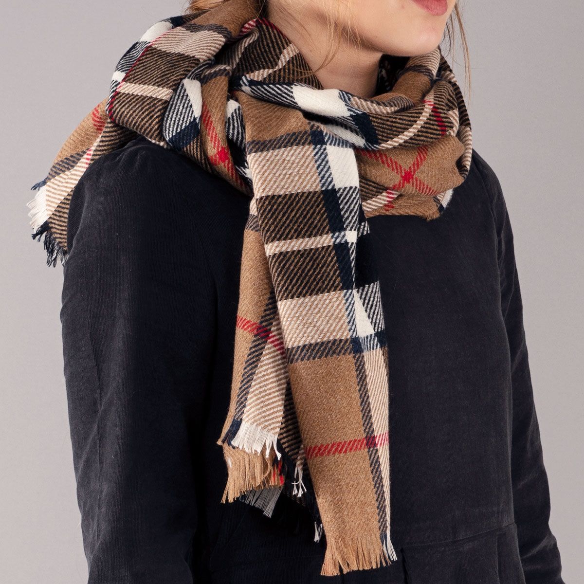 Brown, black, and white plaid scarf with frayed edges.