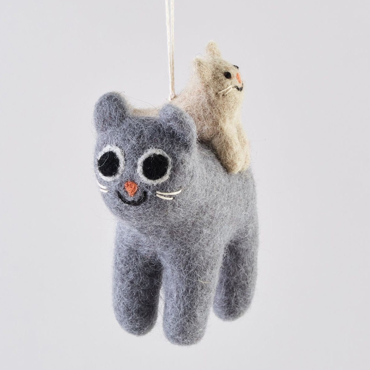Gray felt cat ornament with a smaller beige cat on its back.  The larger cat has embroidered facial features.
