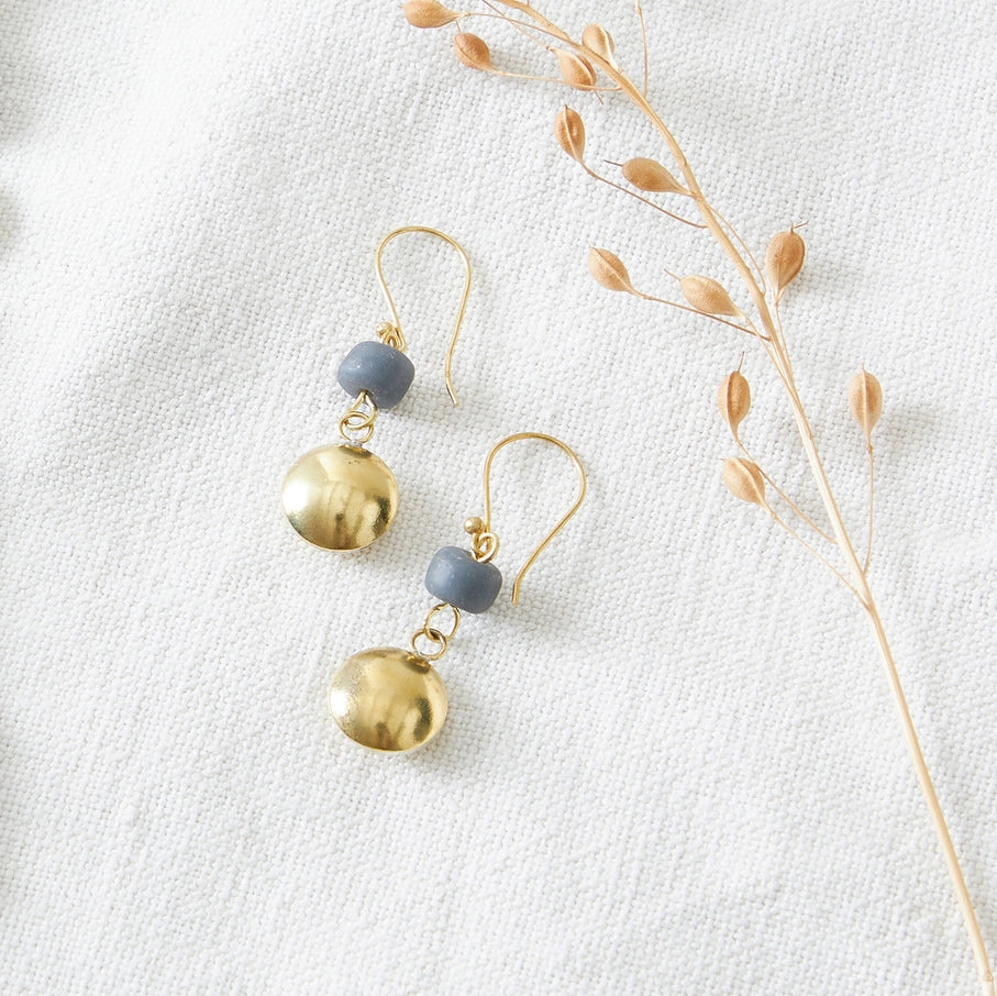 Pair of gold and gray dangle earrings. Each earring features a small gray bead and a larger gold disc.