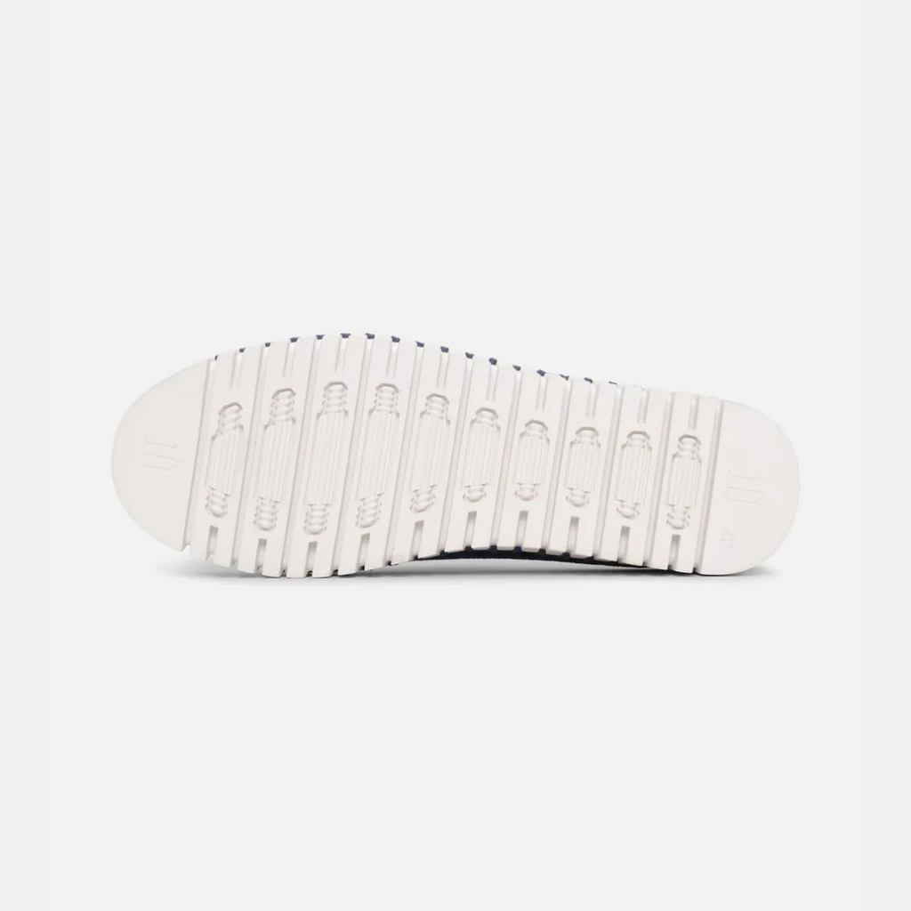 Navy blue shoe sole with off-white textured tread, showing repeating oval patterns and subtle branding.
